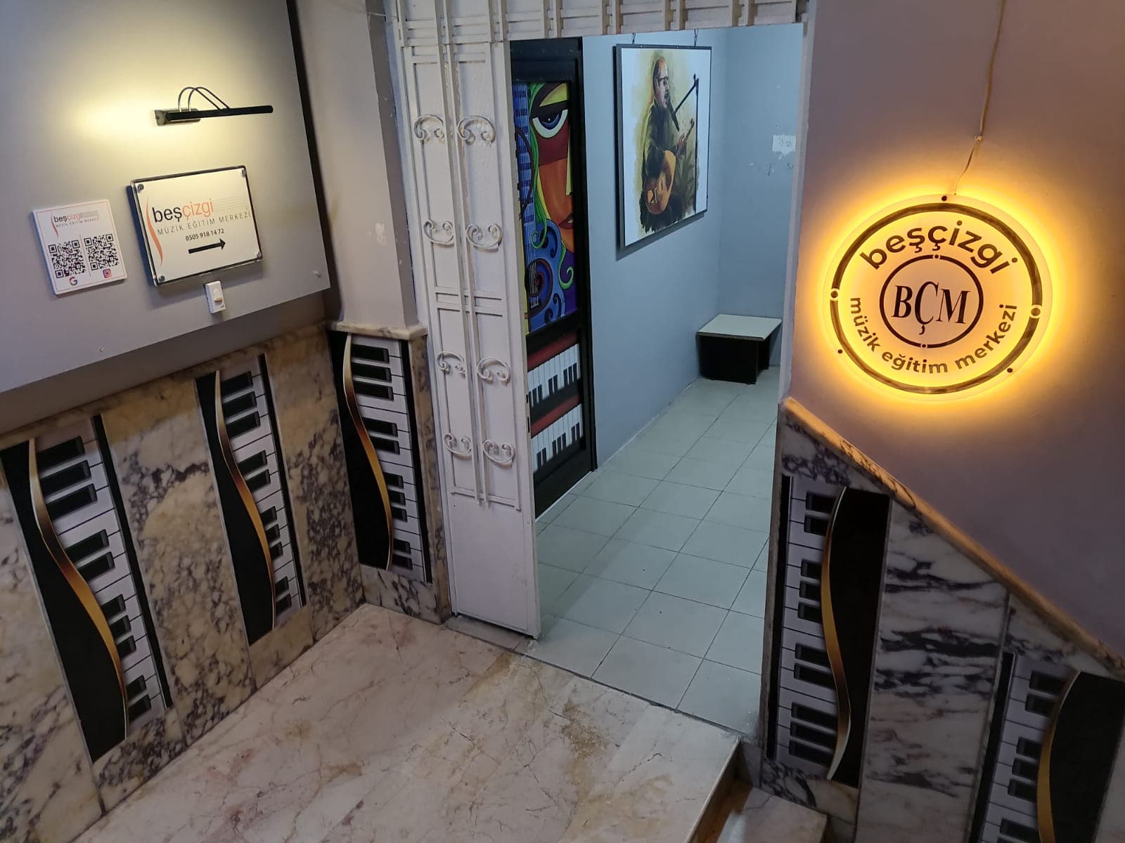 Giriş merdiveni ve beşçizgi neon logosu